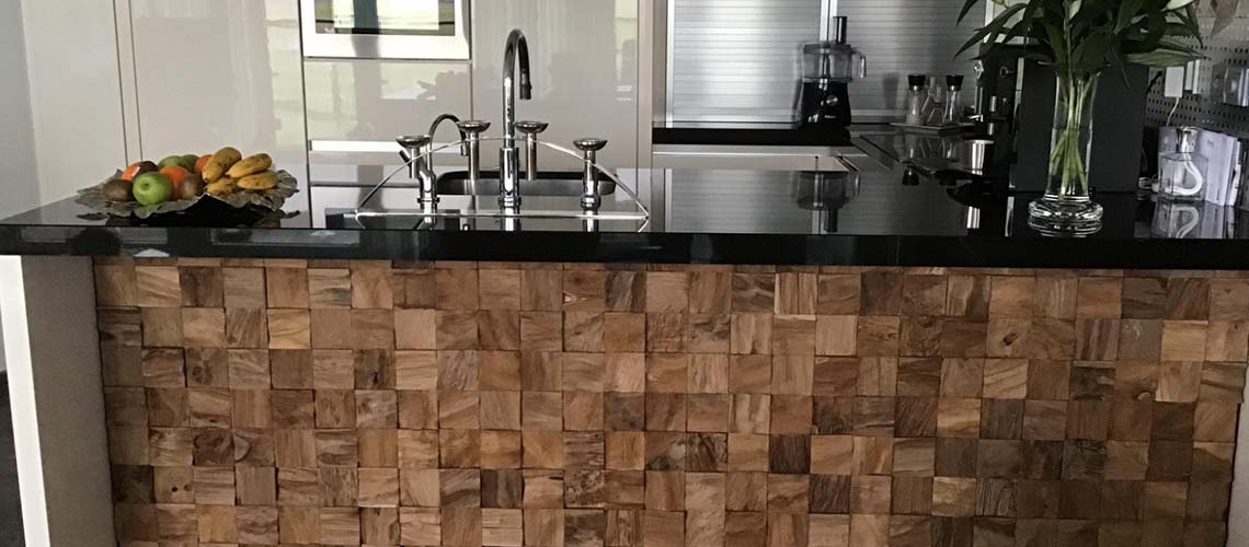 Keuken met mozaïek houten blokken en zwart aanrechtblad