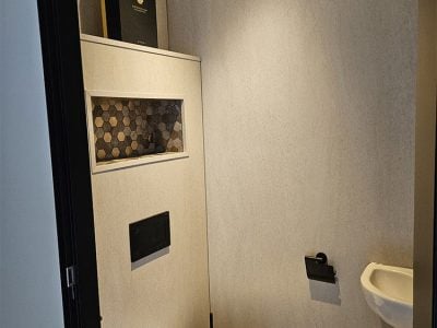 Stijlvol toilet met grijze wandtegels en ingebouwde nis met hexagonale tegels