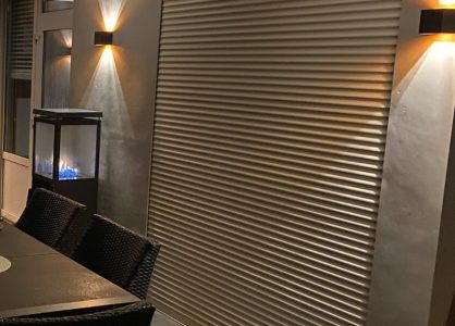 Sfeerverlichting aan beton cire wand en terras met vuurtafel