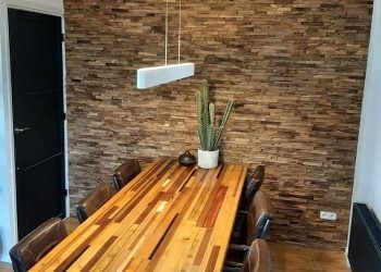 industriele-wand-woonkamer.jpg Woonkamer met industriële donkere muur, decoratieve spiegel en kast