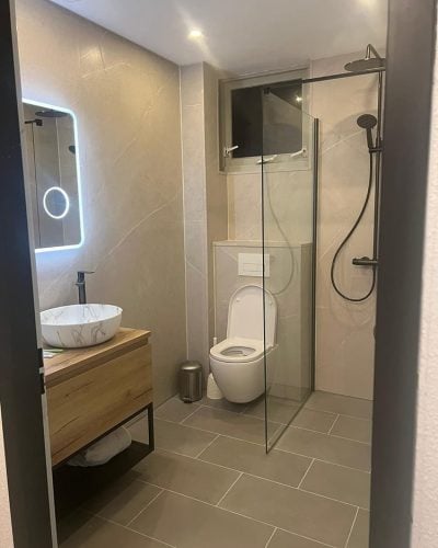 Hotel chique badkamer met glazen douchewand en houten wastafel