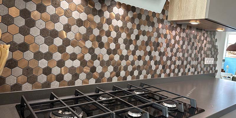 Keuken met hexagonale bruin en beige tegel achterwand en gasfornuis