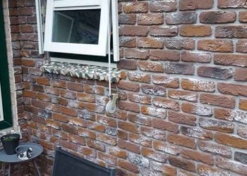 lambrisering-hout Woonkamer met donkere industriële bakstenen muur en verlichting