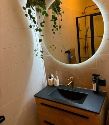 Badkamer met ronde spiegel en planten Scandinavisch stijl