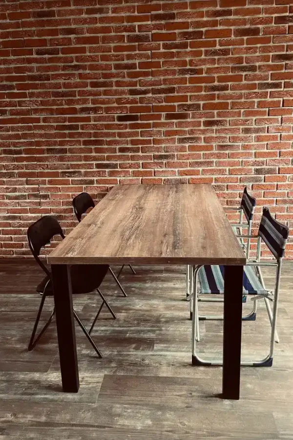 baksteen raja eethoek woonkamer Minimalistische eetkamer met houten tafel, zwarte stoelen en bakstenen accentmuur, industrieel geïnspireerd ontwerp