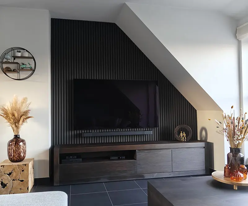 Dezelfde woonkamerhoek met zwarte verticale akoestische panelen achter de tv voor een warmere en modernere uitstraling