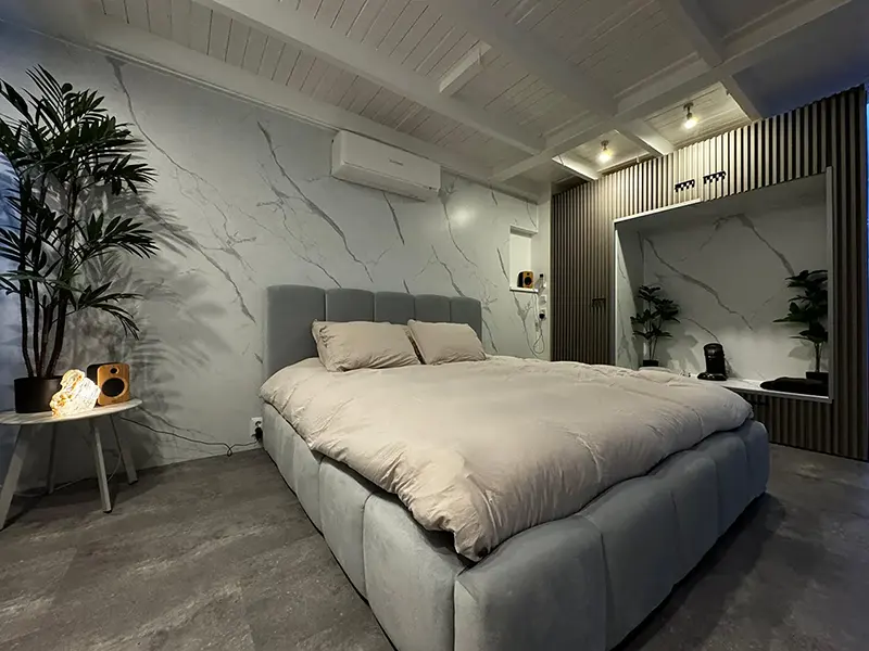 Slaapkamer met marmer Calacatta wandbekleding Slaapkamer met marmer Calacatta wandbekleding, witte marmerlook met goudaders, houten accenten en rustige, elegante sfeer.