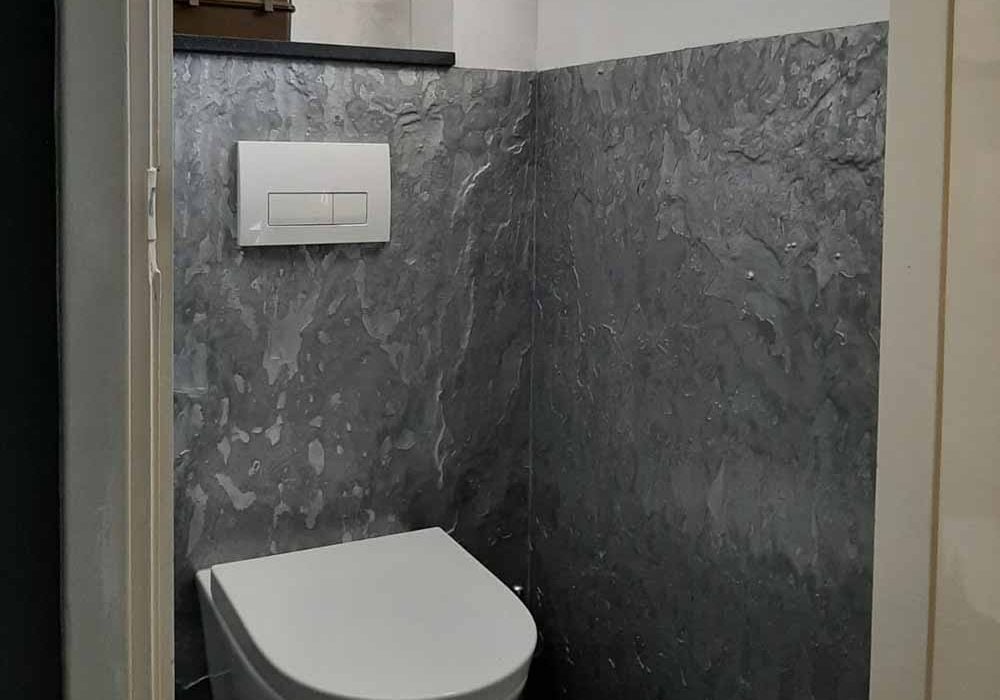 metallic-stuc-lambrisering.jpg Toilet met grijze metallic stuc lambrisering zwevend toilet en ingebouwde spoelknoppen