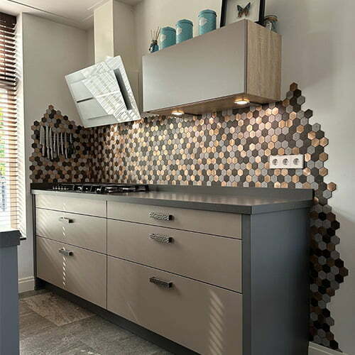 Keuken met grijze kasten hexagonale mozaiek tegels achterwand houten planken en ingebouwde verlichting