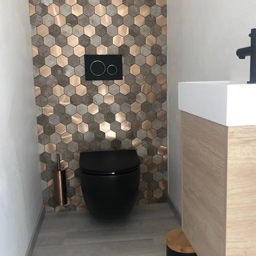 Toilet met hexagonale mozaiek tegel wand in aardetinten zwevend toilet en houten accessoires