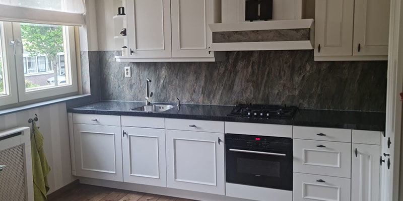 Witte keuken met natuursteen keuken achterwand in grijs en zwarte accenten