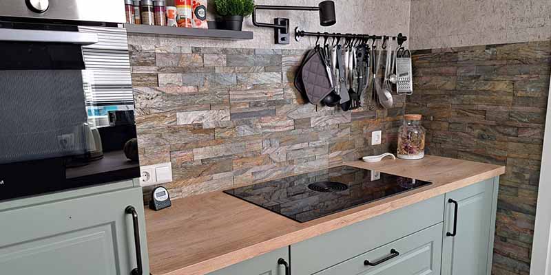 Keuken achterwand met modern gasfornuis en veelkleurige steenstrips
