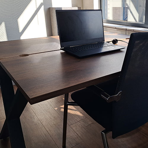 Minimalistische thuiswerkplek met laptop op een houten bureau in een lichte kamer