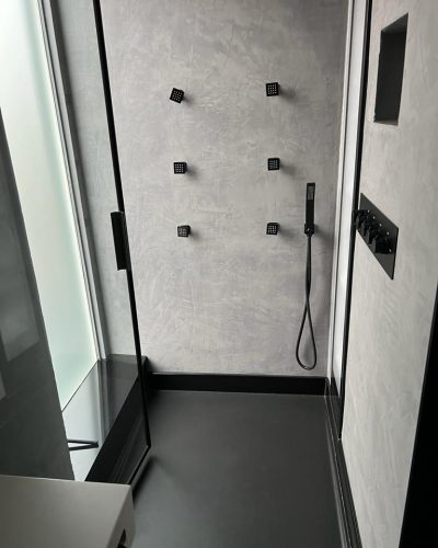 Minimalistische douche met grijze muren en zwarte accenten hotel chique