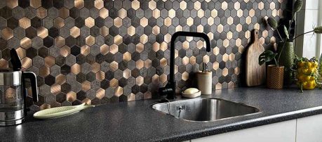 Keuken met hexagon mozaiek wandbekleding met een zwarte kraan en werkblad