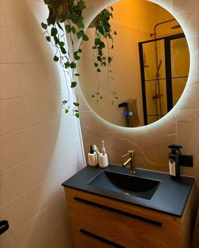 Badkamer met ronde spiegel en planten Scandinavisch stijl